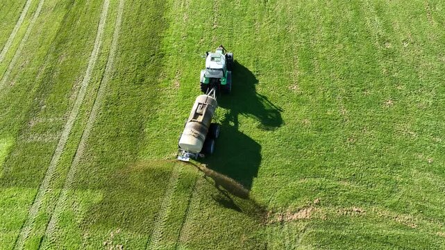 Drohnenvideo von einem Traktor der G&uuml;lle oder Jauche auf einem Feld ausbreitet