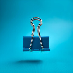 Binder clips floating or flying isolated on light blue background