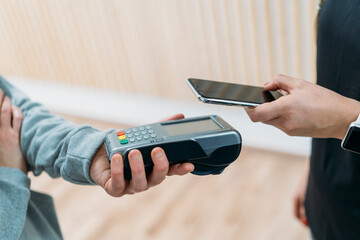 Customer using smartphone nfc technology to make a purchase at a store
