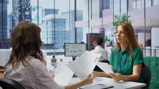 Human resources staff evaluating candidates resume in the selection process, reviewing all applicants after job interview in order to hire the right person. Recruiters seeking personnel. Camera B.