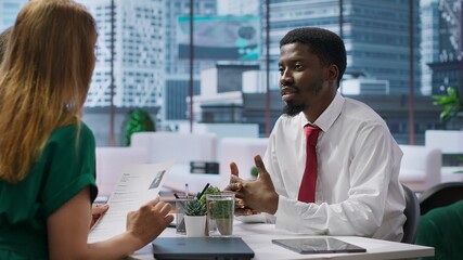 Two businesswomen engage in a job interview with a new candidate, reviewing the applicant CV and discussing aspects of potential employment and career progression. HR department. Camera A.