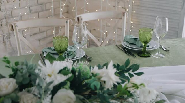 The festive table is set for two people and decorated with fresh flowers
