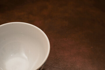 A empty blue pattern ceramic bowl with white inside isolated on brown background, Blue porcelain ceramic bowl.
