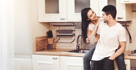 Lovely Family Concept. Portrait of cheerful couple drinking tea in modern kitchen, spending time together