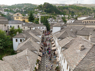 Aerial Top view Drone Shot of the central streets in Gjirokastra, Albania. Crowded Center, Souvenir shop, Cafe, Tourist
