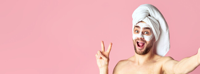 Man skin care and selfie. Millennial guy with mask on his face shows peace sign