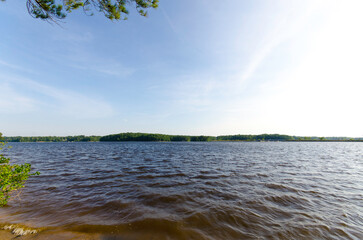 Expansive View Of A Tranquil Lake Under Clear Skies