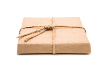 Gift box wrapped in eco craft paper with jute bow isolated on white background with copy space.