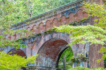 An old Japanese aqueduct surrounded by beautiful greenery.