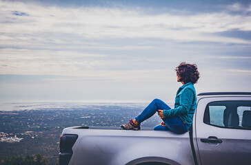 A woman in a 4x4 car overlooks the sweeping landscape of the Algarve from the high vantage point of Cerro de São Miguel.