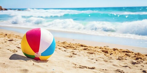 Obraz premium Colorful Beach Ball Bouncing on a Sandy Shore with Ocean Waves, Capturing the Fun of a Beach Day