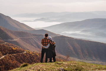 A happy couple who hikers enjoys a break look at the top of the mountain adventure travel.