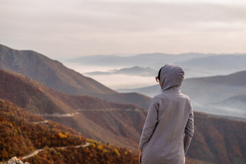 A woman traveler enjoys a break look at the top of the mountain.