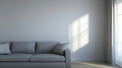 Fototapeta premium A large gray couch sits in a room with a white wall and a window