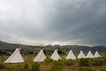 Seven Teepees Stand In Field With Gardiner Montana In The Distance © kellyvandellen