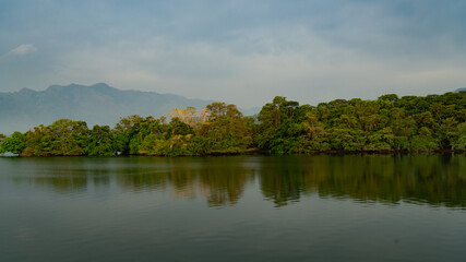panoramic landscape view of clouds and forest reflecting on the water