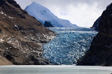 Majestic Chorten Nyima Glacier in Tibet, showcasing intricate ice formations against rugged mountain slopes, a breathtaking view of natural beauty.