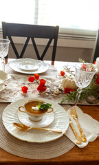 Orange pumpkin and ginger soup served on gold rimmed white fine China plates