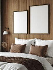 Cozy bedroom scene with neat bed with white pillows and light blanket and a blank hanging picture on the wall