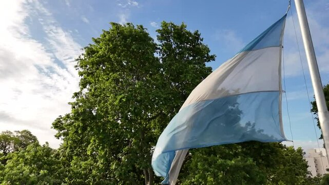 bandera argentina flameando sobre sol, cielo azul	