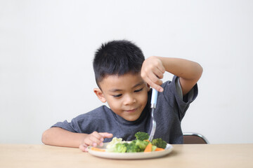 Nutrition healthy eating habits for kids concept. Children do not like to eat vegetables. Little cute boy refuses to eat healthy vegetables.