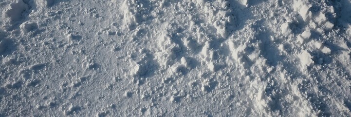Natural snow texture top view. surface of the snow crust. Snowy ground. Winter background with snow patterns, banner template Merry Christmas and Happy New Year
