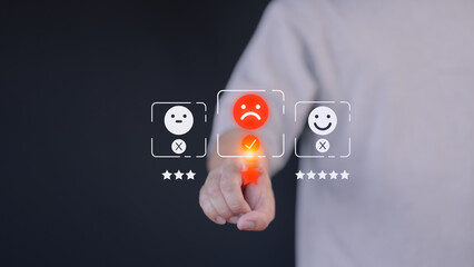 A hand hovers over a digital rating interface, selecting a one-star rating with a sad face icon....