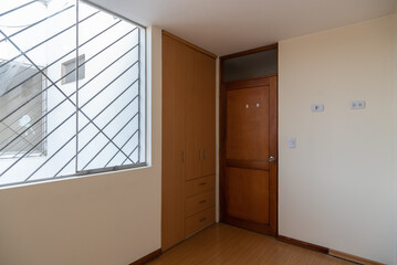 habitacion de departamento con closet  incorporado con acabados de melamina y madera 