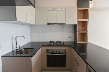 cocina moderna con estufa amoblado con alacenas de melamina con acabados de madera en departamento