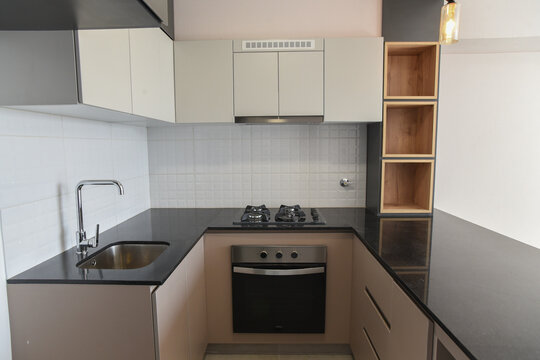 cocina moderna con estufa amoblado con alacenas de melamina con acabados de madera en departamento