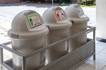 Trash can with three compartments based on categories for recycling at school