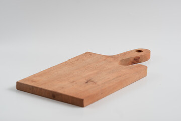 Food preparation tool and kitchen utensils concept with close-up on rectangular wood chopping board with round corners isolated on white background at an angle perspective with clipping path cutout