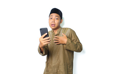 asian muslim man holding mobile phone touching his chest show shocked expression  isolated on white background, looking at camera