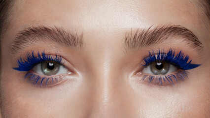 Obraz premium Electric Blue Mascara, Bold Minimalism: A front-facing close-up of both eyes, where each lash is coated in vibrant electric blue mascara, standing out strikingly against natural, makeup-free skin