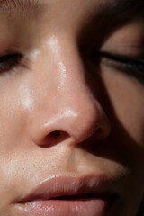 Naklejka premium Stylish Minimalism, An extreme close-up shot of the eyes showcasing dewy skin around the eye area: The model's face is captured with a focus on the eyes, emphasizing the bright