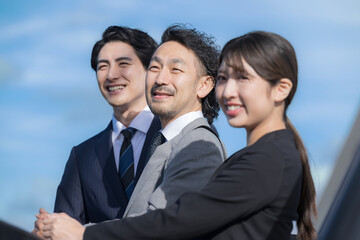 Banner of a team of three business people looking up to the future, hope and blue skies.