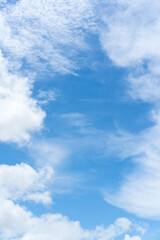 Blue sky with clouds as a border frame. Vertical shot.