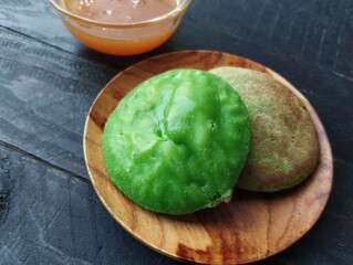Serabi hijau or Indonesian traditional cake made from rice flour mixed coconut palm sugar on the wooden table