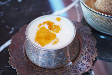 woman eating yogurt soup, traditional soup with chickpeas and mint.