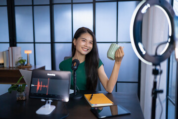 Happy young female making audio podcast in studio asian woman recording podcast on tablet with...