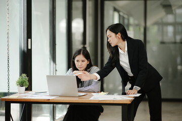 Two business women sitting and working Documents in front of the computer
