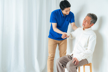 Obraz premium マッサージ、ストレッチ、リハビリ、肩、肩痛、トレーナー、五十肩、治療、関節、患者、男性、日本人、高齢者、四十肩、シニア、中高年、お年寄り、老人、ケアスタッフ、ヘルパー、相談、診断、診療、理学療法士、整体、整体師、診察、介護士、介護、肩関節周囲炎、ローテーターカフ損傷、肩峰下滑液包炎、肩こり、加齢、老化、リハビリテーション、インナーマッスル、トレーニング、腱板損傷、肩蜂下インピンジメント症候群、痛み