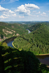 Saar river at a bend surrounded by trees on hills on a sunny spring afternoon in Germany.
