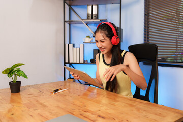 Young Asian woman listening to music, happy
