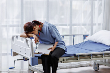 Medical nurse is on bed in hospital sitting down a the hospital corridor in frustration and grief...
