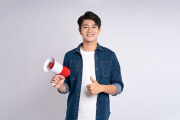 Portrait of young Asian man holding shopping and atm card bag posing on white background