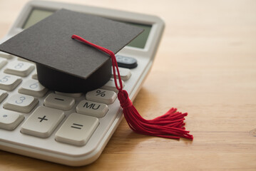 Mortarboard on white calculator. Money financial management and planning for education, student...