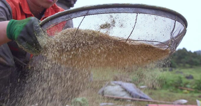 Sifting sand through a sieve, slow motion