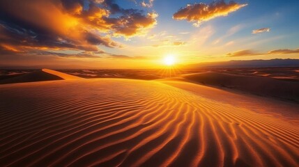 Sunset over desert dunes with orange sky.