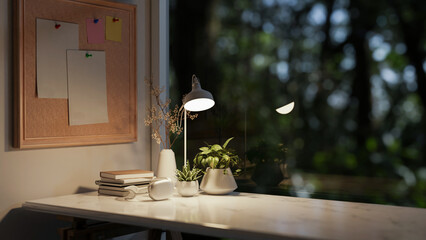 A minimalist office desk or home office workspace at night, illuminated by a table lamp.